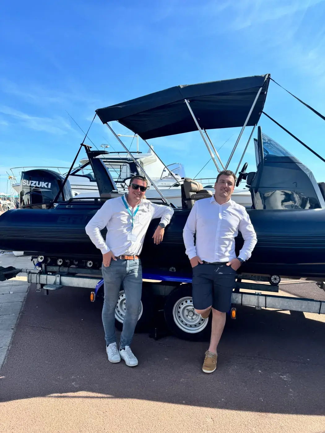 Julien, à gauche, et Pierre, à droite, devant un semi-rigide sur un salon nautique