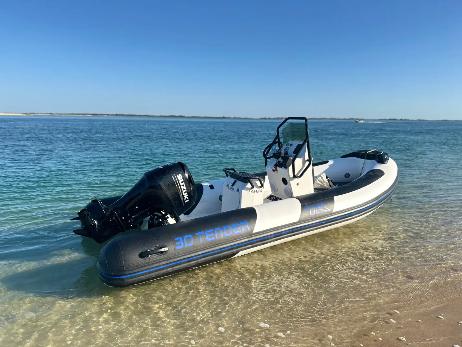 Le semi-rigide 3D Tender TR54 posé dans l'eau claire, face à la plage de la Patache